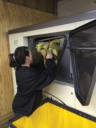 6 An employee at GearClean, an independent service provider, loads turnout gear into an Esporta Wash System machine. (Photo courtesy of GearClean