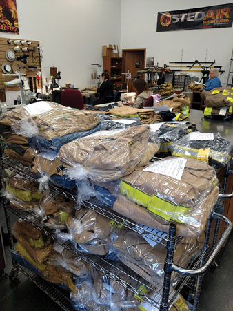 7 Turnout gear that’s been cleaned and repaired sits on racks at Shamrock Gear Restoration prior to being shipped back to the respective fire departments. (Photo courtesy of Shamrock Gear Restoration