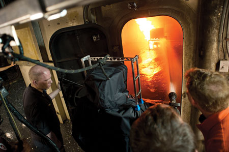 4 John Farley, a Virginia Tech engineering student, right, and two unidentified researchers watch as the Navy’s robot operates a one-inch handline to extinguish a fire in a shipboard compartment. 