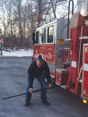 3 A firefighter measuring the outrigger placement off a Seagrave Aerialscope. <em>(Photo by John Ciampo.)</em> 