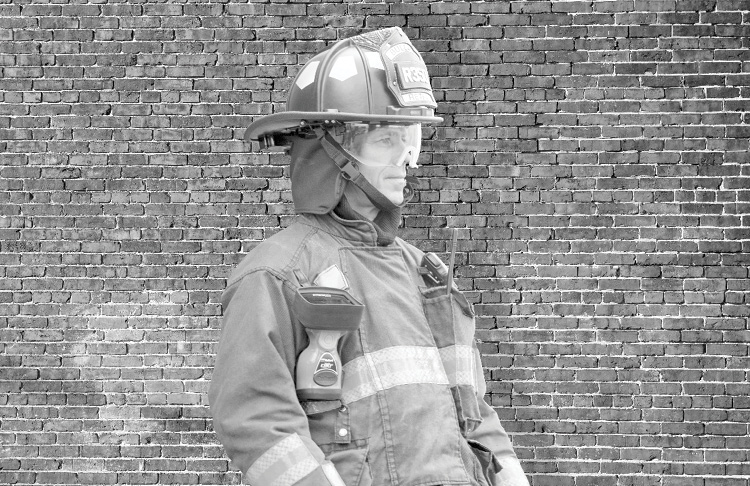 At midday, a firefighter may blend in with the background because his apparent body temperature is nearly the same as the brick wall behind him. 
