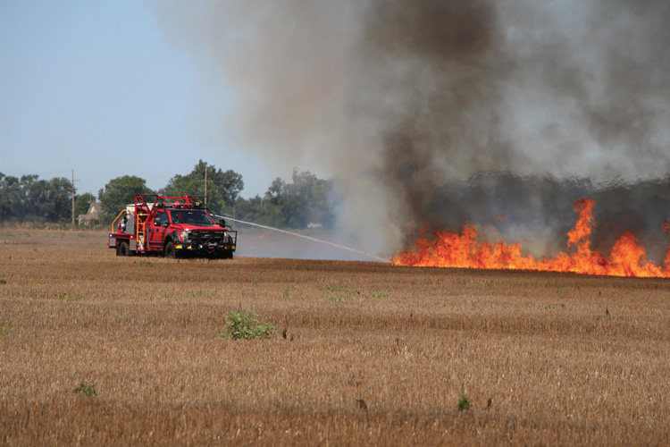 A Blanchat-built Type 6 wildland engine operates in the fuel while using its midship-located attack line to fight a prairie fire.