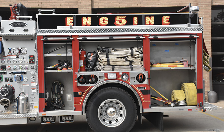 The driver’s side with 2½-inch roll-ups, fittings, a 50-foot section of five-inch hose, an SCBA for the driver, and spare SCBA cylinders.