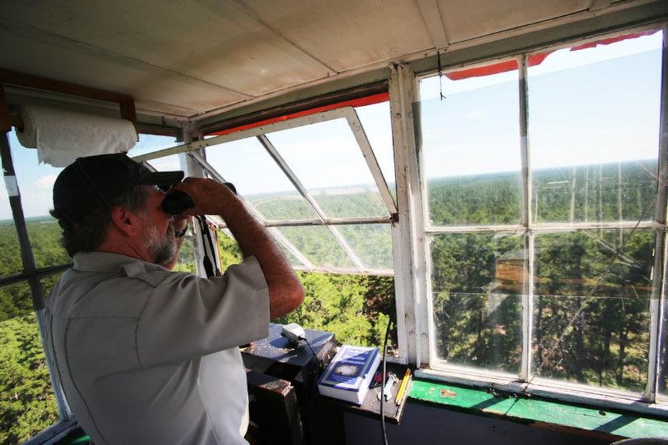 New Jersey Forest Fire Service fire observer Craig Watson stands in the Apple Pie Hill fire tower alongside an Alidade, an instrument used to determine the location of any fires he spots Sept. 15, 2016. A different state Division B tower, the Lakewood Fire Tower, will be removed later this year, state officials said in July 2024. (Brian Donohue )