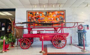 An antique hand pump. The mural behind it depicts scenes of the Chicago Fire Department in action. (Photos by Mike Ciampo)